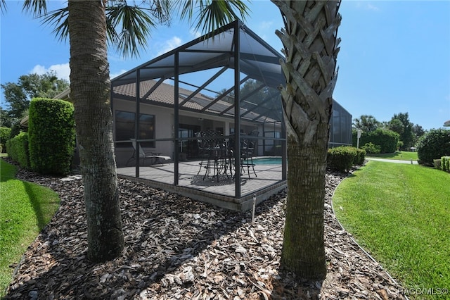 view of yard featuring glass enclosure and a patio area