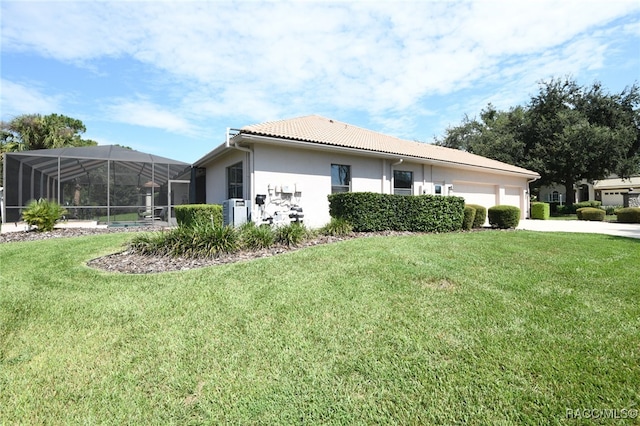 view of side of property with a lawn and glass enclosure