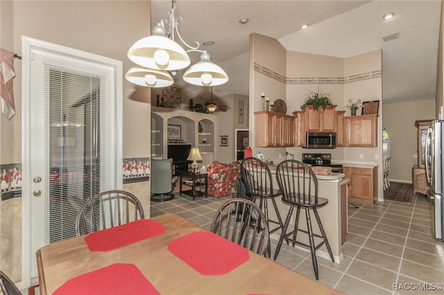 tiled dining room featuring a chandelier and lofted ceiling