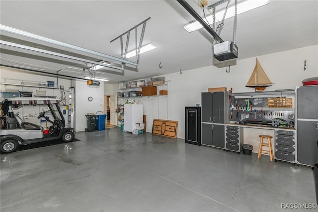 garage with a workshop area and a garage door opener