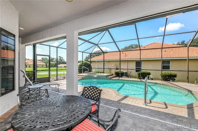 view of swimming pool with a lanai, a patio area, and an in ground hot tub