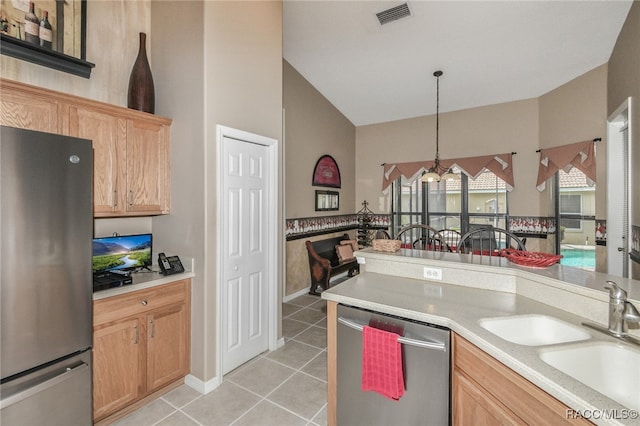 kitchen featuring pendant lighting, sink, light tile patterned flooring, stainless steel appliances, and a chandelier