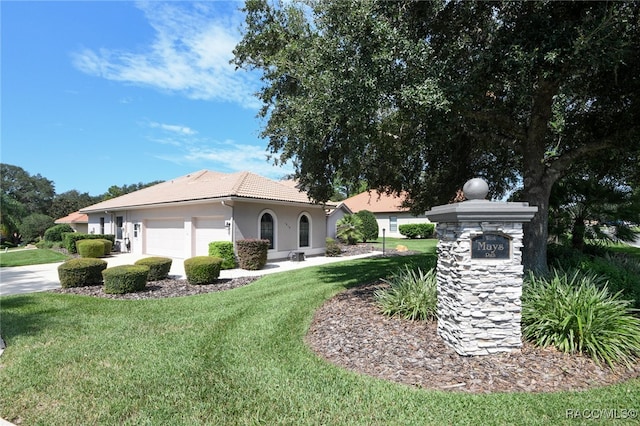 view of front of home with a front yard and a garage