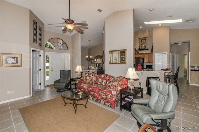 tiled living room featuring ceiling fan with notable chandelier and high vaulted ceiling