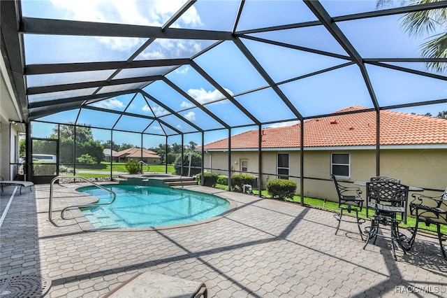 view of pool with glass enclosure and a patio area