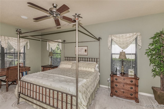 bedroom featuring light carpet, ceiling fan, and a textured ceiling