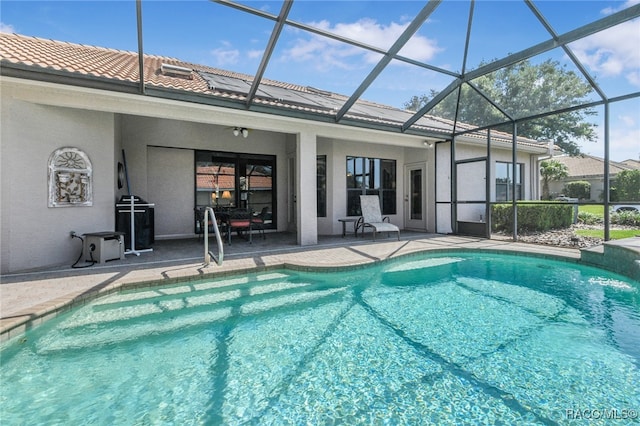 view of swimming pool featuring glass enclosure and a patio area