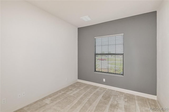 spare room featuring light colored carpet