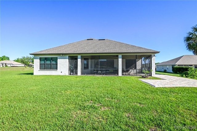 back of house featuring a lawn and a sunroom