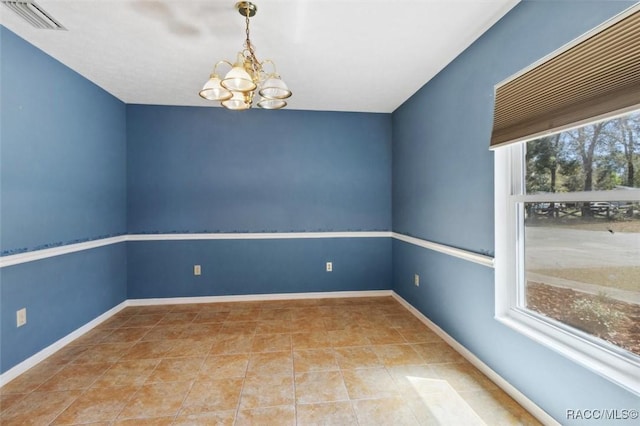 tiled spare room featuring visible vents, plenty of natural light, baseboards, and an inviting chandelier