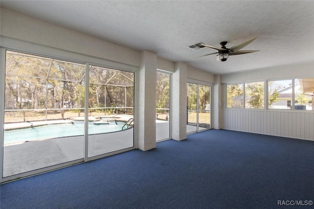 unfurnished sunroom with visible vents and a ceiling fan