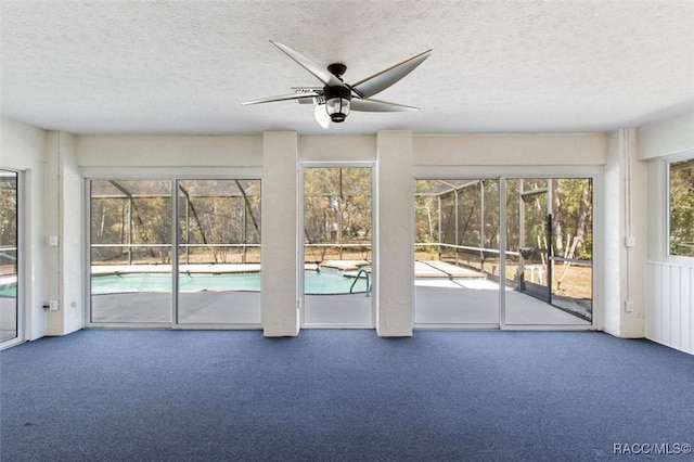 entryway featuring a sunroom, carpet, a ceiling fan, and a textured ceiling