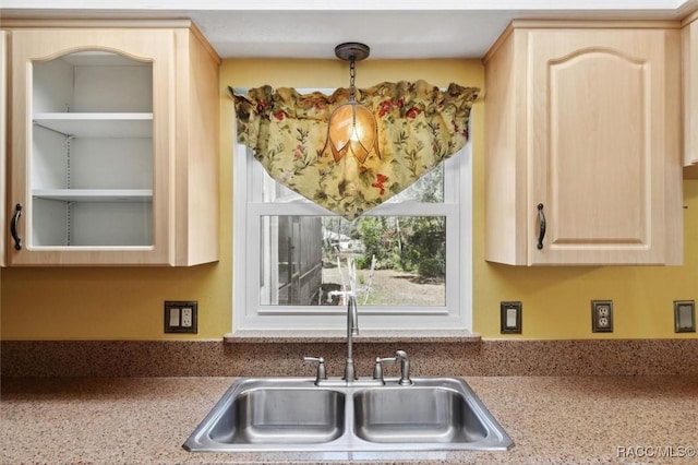 kitchen with light countertops, a sink, and light brown cabinetry