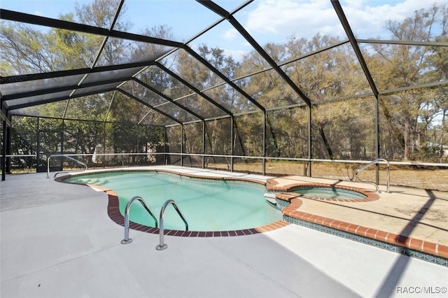 view of pool with a patio area, a lanai, and a pool with connected hot tub