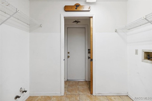 washroom featuring laundry area, hookup for a washing machine, baseboards, and tile patterned floors