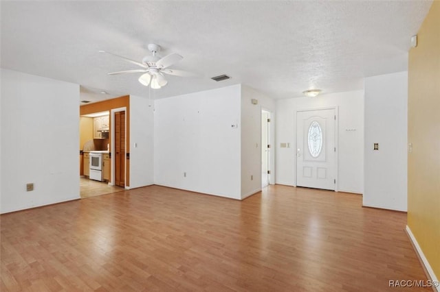 foyer featuring light wood-style floors, visible vents, a textured ceiling, and a ceiling fan