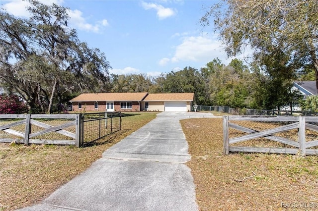 single story home featuring a fenced front yard, a front yard, a gate, and a garage