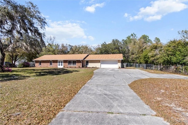 ranch-style home featuring brick siding, a front yard, fence, a garage, and driveway