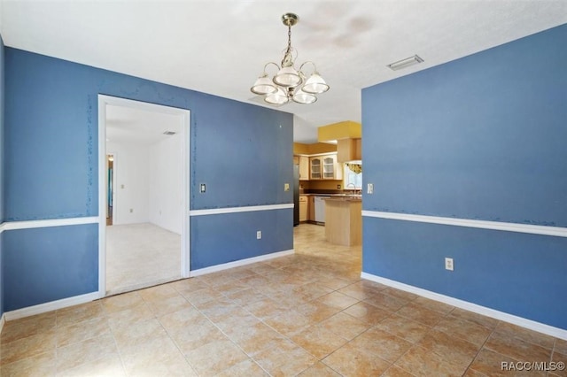 empty room featuring an inviting chandelier, baseboards, and visible vents