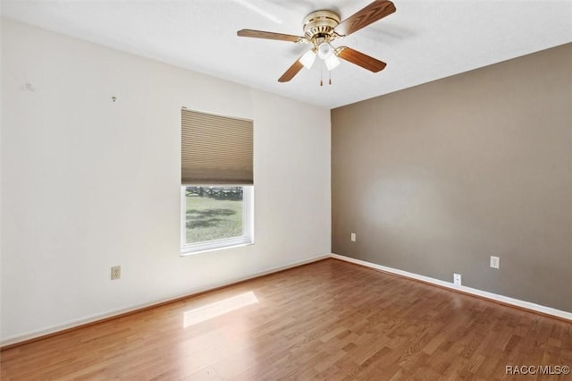 empty room with ceiling fan, baseboards, and wood finished floors