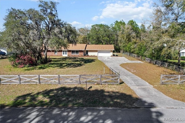 ranch-style house featuring driveway, a front lawn, a fenced front yard, and an attached garage