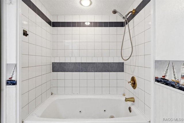 full bath with a combined bath / shower with jetted tub and a textured ceiling