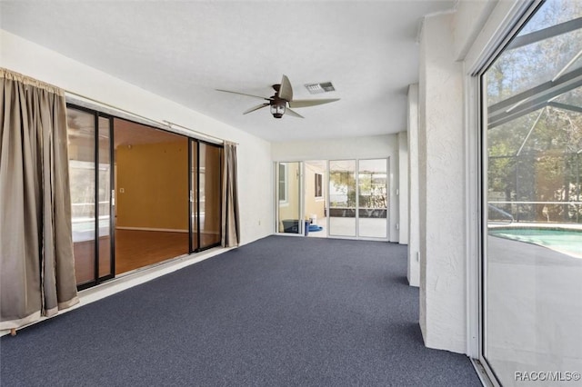 unfurnished sunroom with visible vents and a ceiling fan