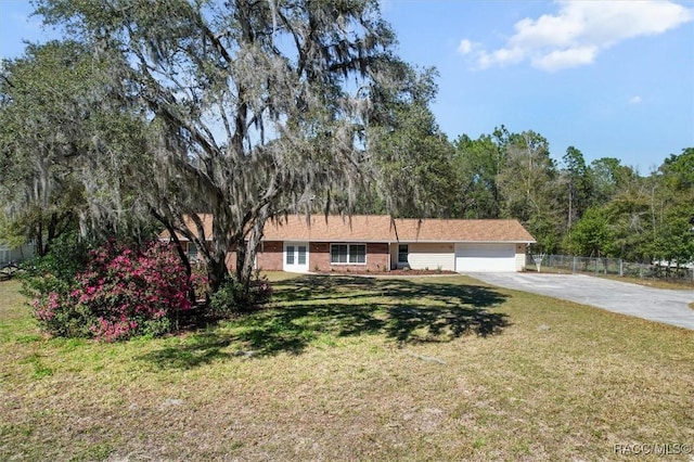 single story home featuring a garage, driveway, fence, a front yard, and brick siding