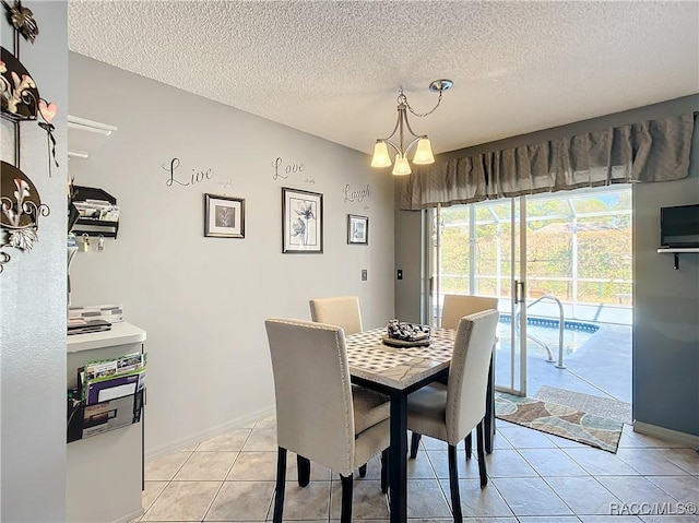 tiled dining space featuring a notable chandelier and a textured ceiling