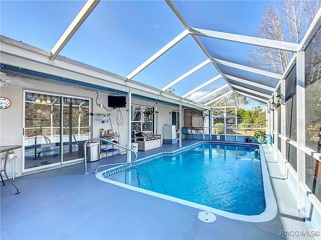 view of swimming pool featuring a lanai and a patio area