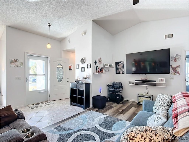 tiled living room with vaulted ceiling and a textured ceiling