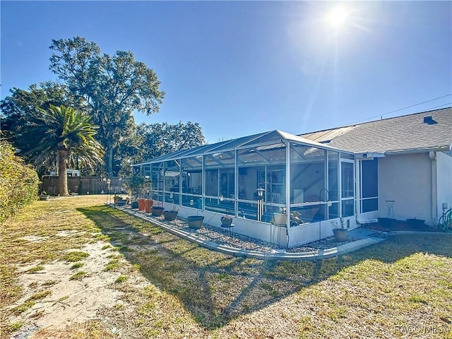 view of side of home with a yard and glass enclosure