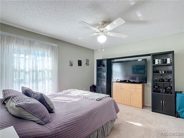 bedroom featuring ceiling fan, light colored carpet, and a textured ceiling