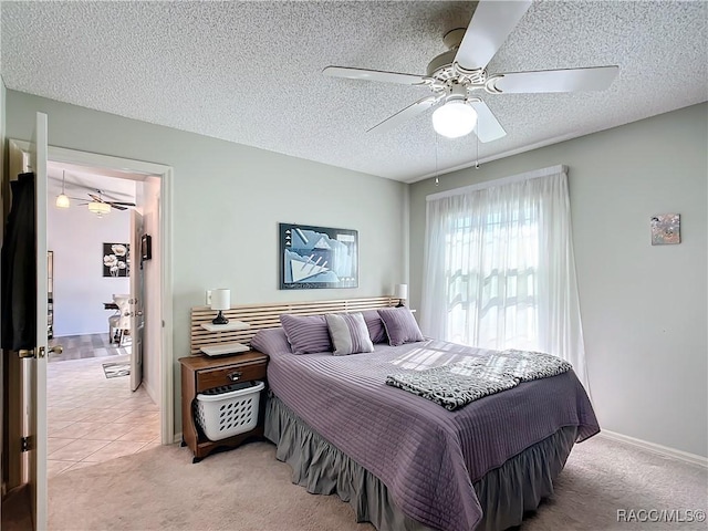 carpeted bedroom featuring ceiling fan and a textured ceiling