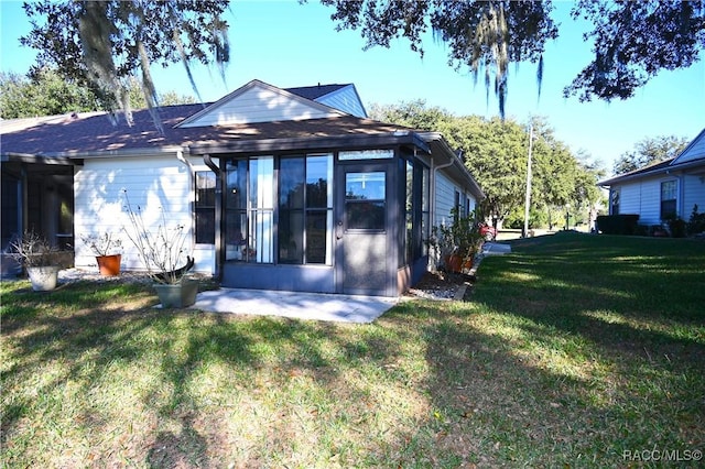 back of house featuring a lawn and a patio