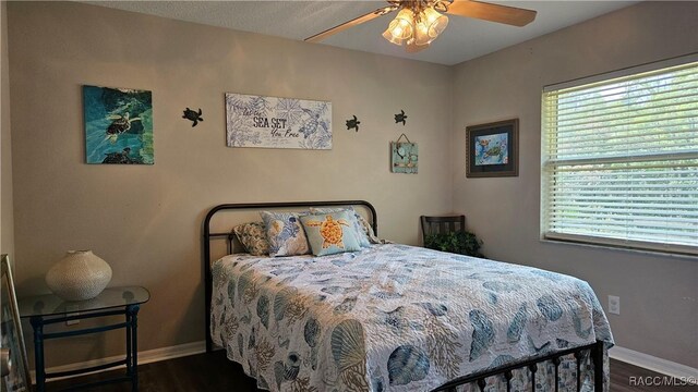 4889 N Peppermint Dr, Beverly Hills, FL 34465 - bedroom featuring baseboards, multiple windows, dark wood-style flooring, and a ceiling fan