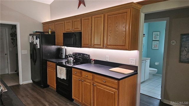 4889 N Peppermint Dr, Beverly Hills, FL 34465 - kitchen with black appliances, dark countertops, dark wood-style floors, and brown cabinets