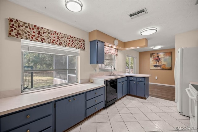 kitchen featuring a peninsula, white appliances, blue cabinetry, and visible vents