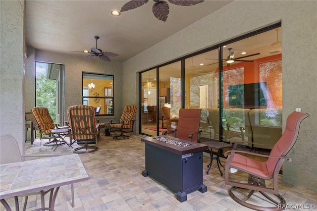 view of patio featuring ceiling fan and a fire pit