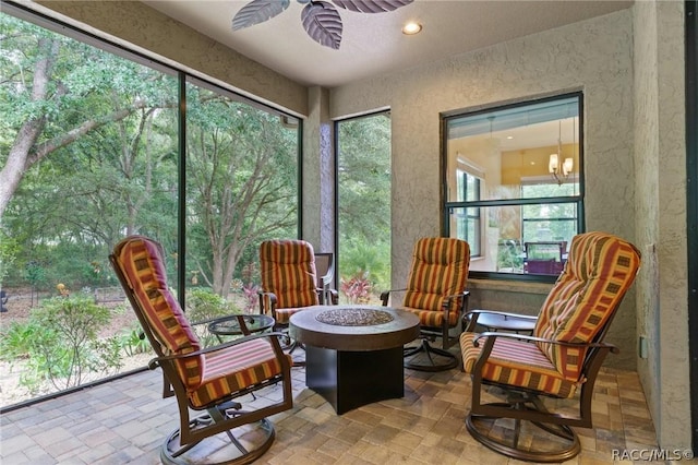 sunroom / solarium featuring plenty of natural light and ceiling fan with notable chandelier