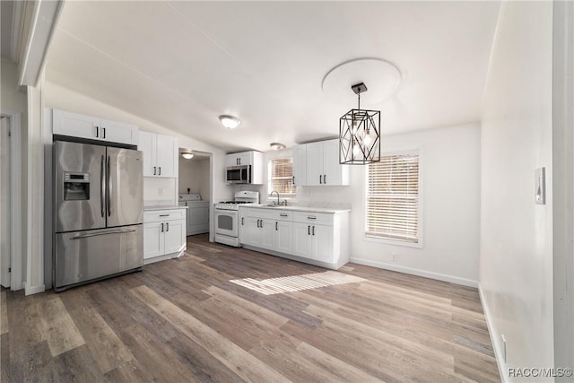 kitchen with appliances with stainless steel finishes, white cabinets, a sink, and light countertops