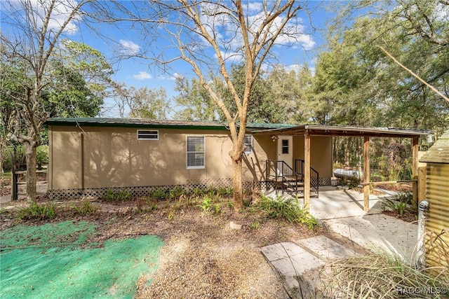 view of home's exterior with stucco siding and a patio