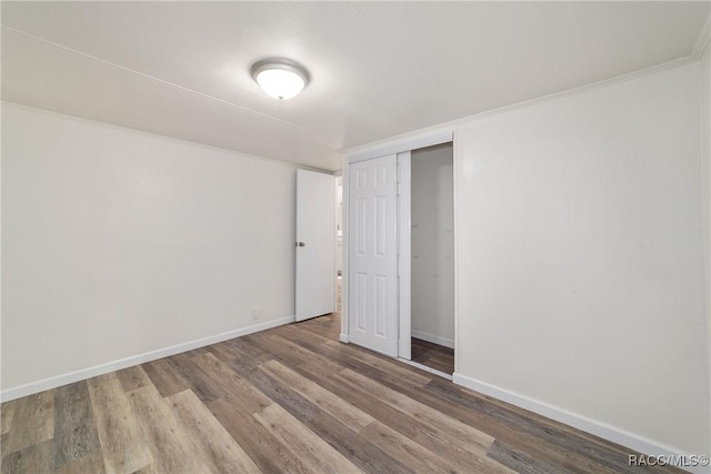 unfurnished bedroom with a closet, baseboards, and wood finished floors