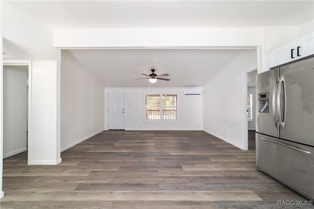 unfurnished living room featuring baseboards, a wall unit AC, wood finished floors, crown molding, and a ceiling fan