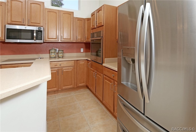 kitchen featuring light tile patterned floors and stainless steel appliances