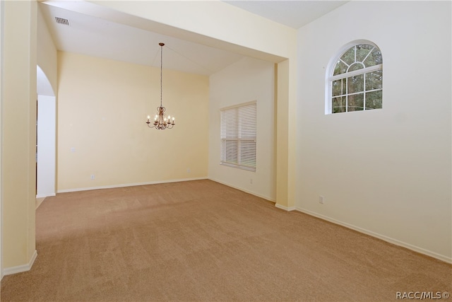 empty room featuring carpet flooring and an inviting chandelier