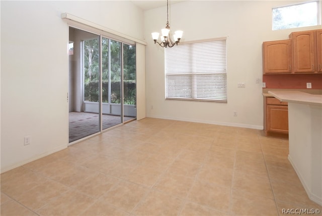 unfurnished dining area with light tile patterned floors and a notable chandelier