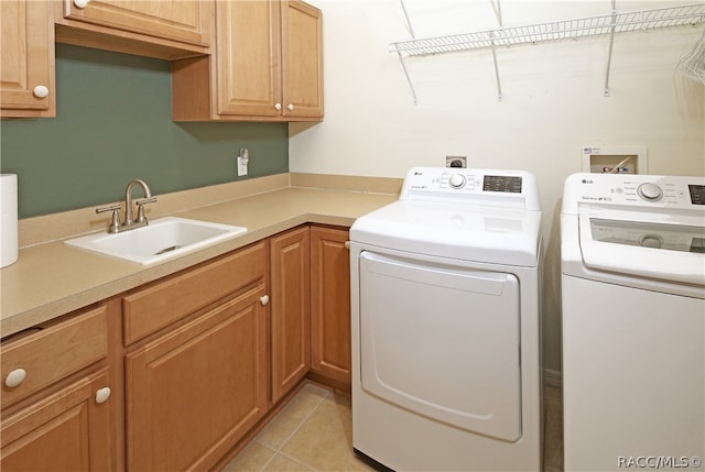 washroom featuring cabinets, separate washer and dryer, sink, and light tile patterned floors