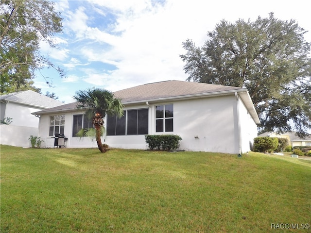 rear view of property featuring a yard