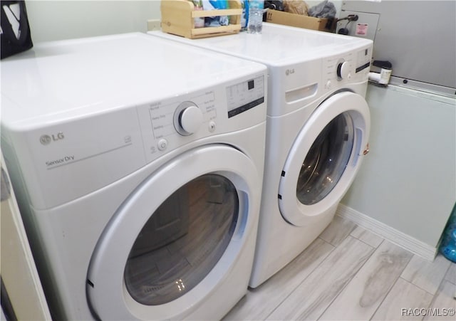 washroom with light wood-type flooring and washing machine and clothes dryer